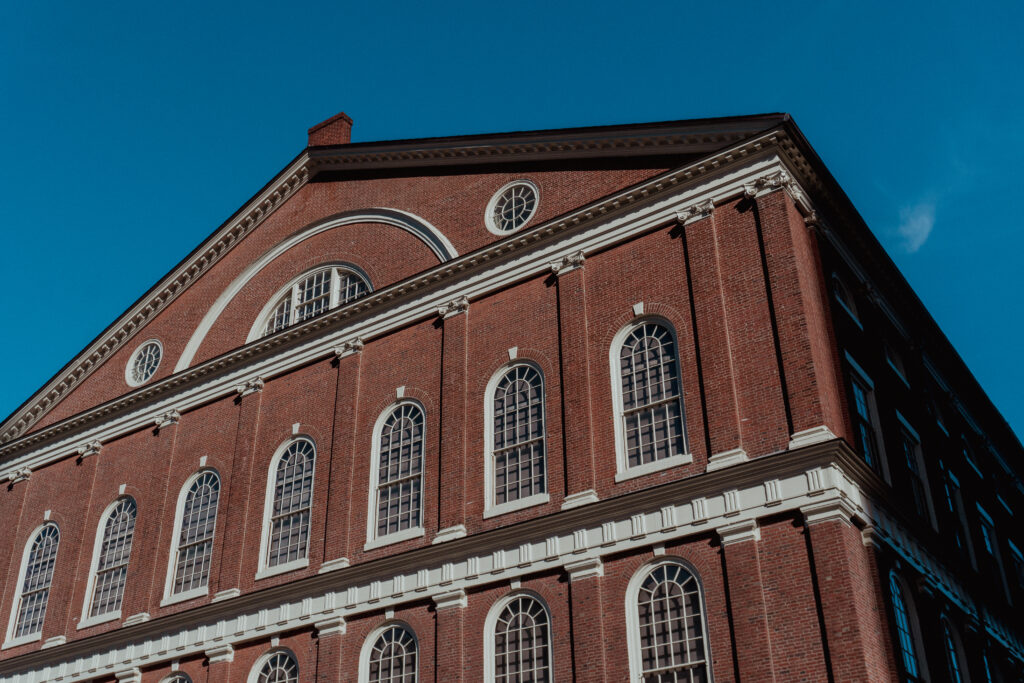 The Faneuil Hall stands tall with red bricks and white windows. 