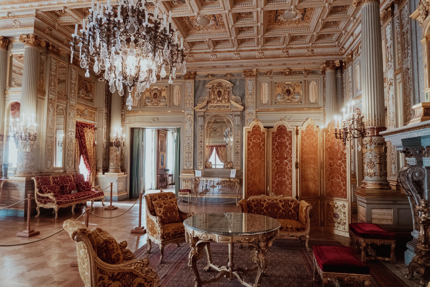 In the historic Breakers Mansion, a chandelier and grand parlor symbolize the wealth of the Guilded Age.
