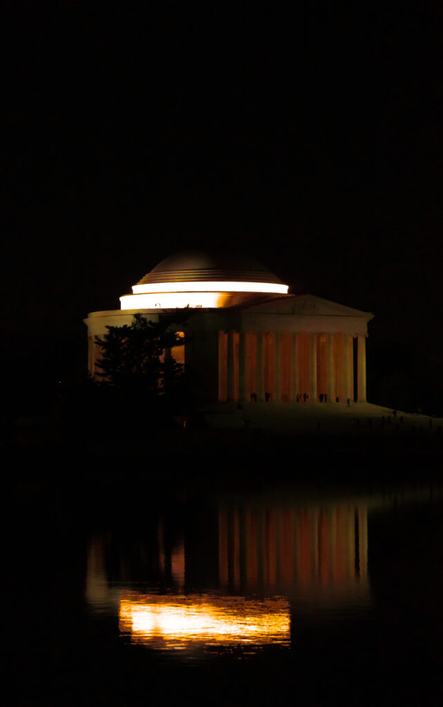 At night, the Jefferson Monument lights up and reflects on Tidal Basin. 