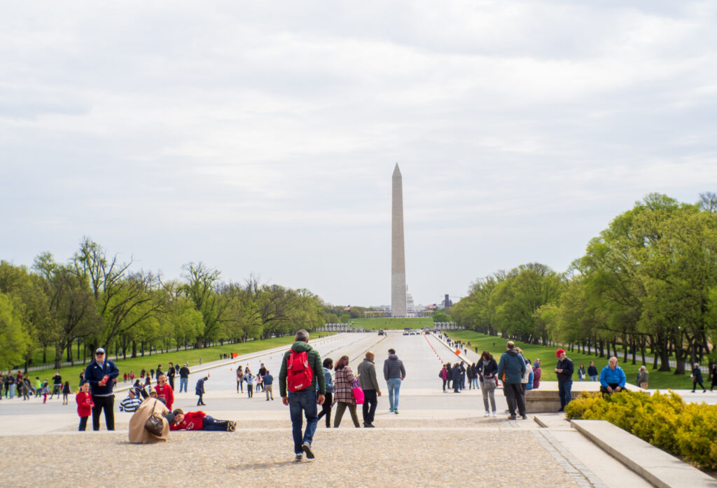 Tourists flock the National Mall and take pictures of the Washington Monument. 