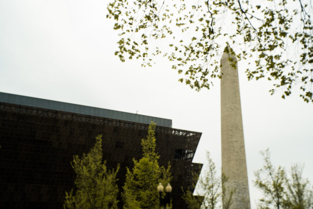 The outside of the African American History and Culture with the Washington Monument in the background. 