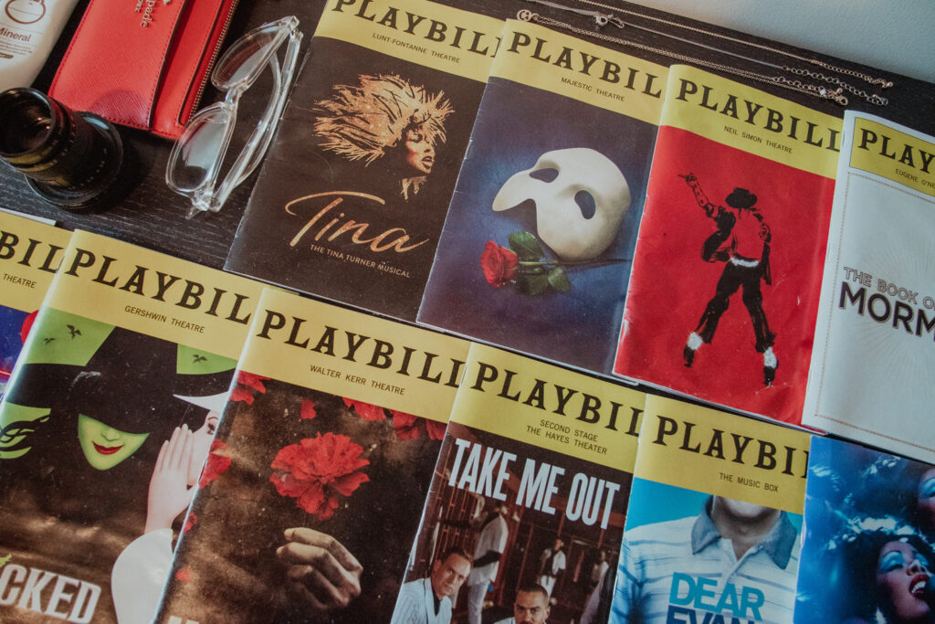 Many Playbills Noah have collected from Broadway sit on his desk. 