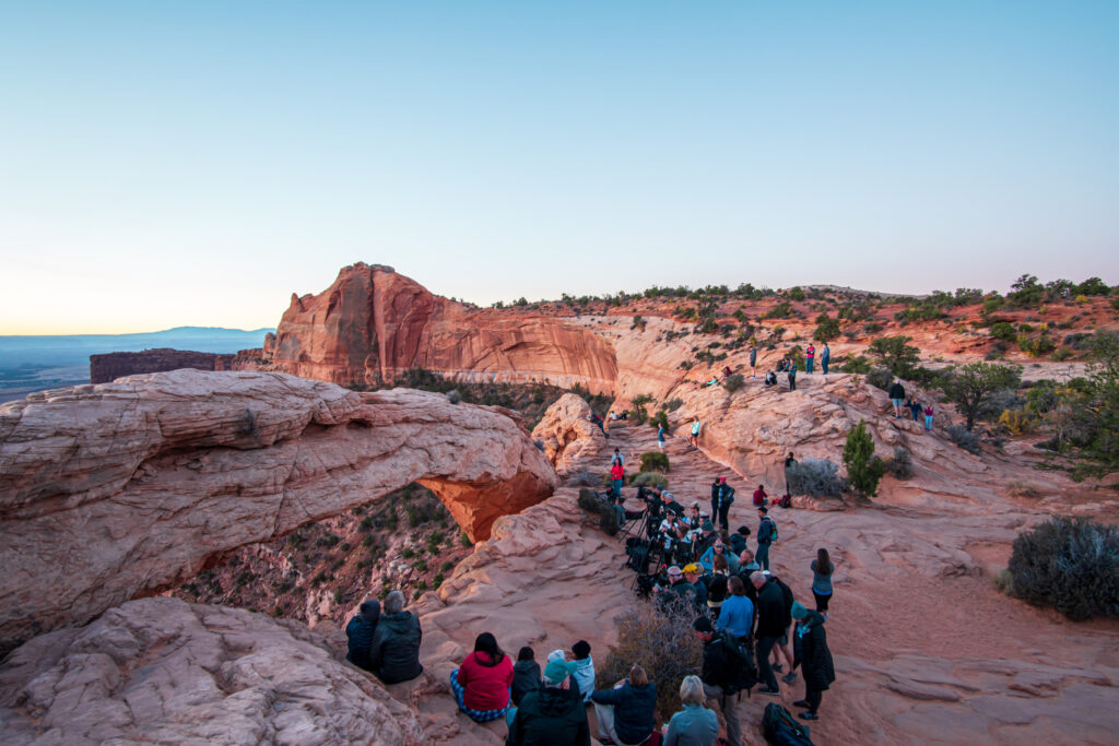Large crowds at Mesa Arch watching the sunrise. 