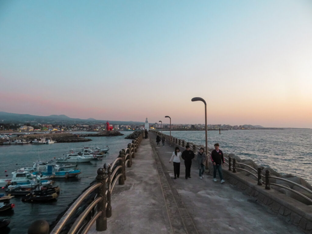 Walkers enjoy the sunset on Jeju Island's shore.