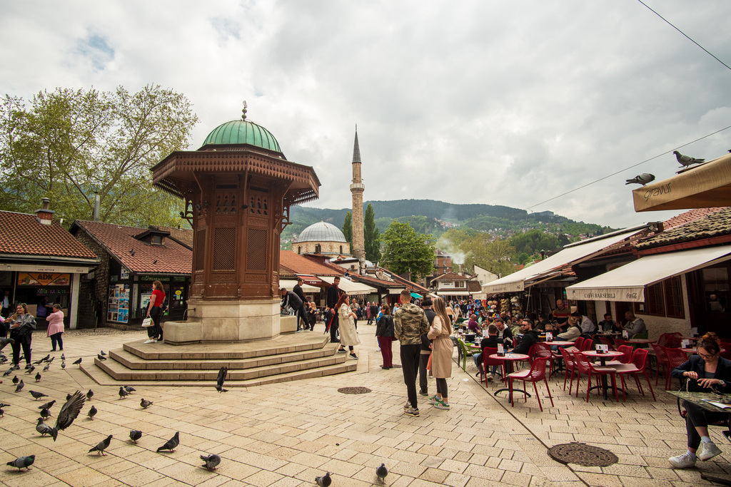 People walk around Sarajevo and drink from its famous fountain in the old town.