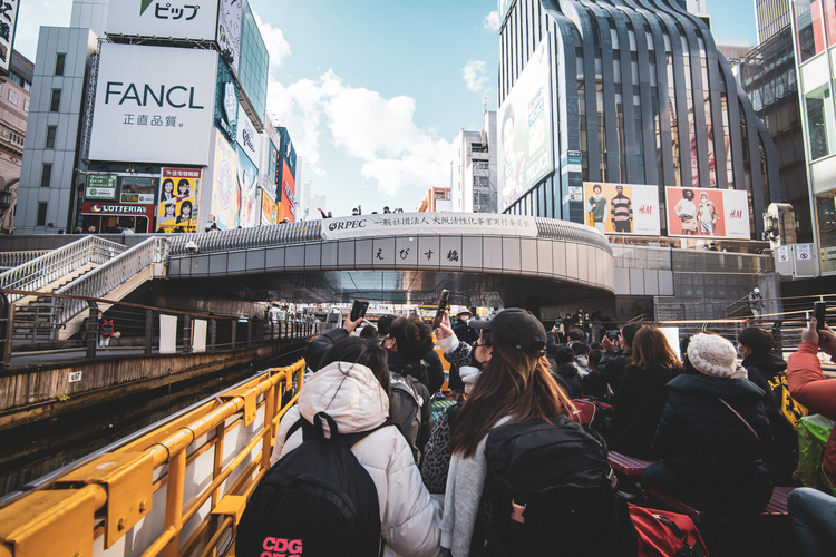 Tourist take a river cruise in Osaka. Doing this tour is fun for an Osaka solo trip.
