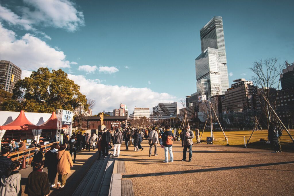 People walk in a park in Osaka, Japan.