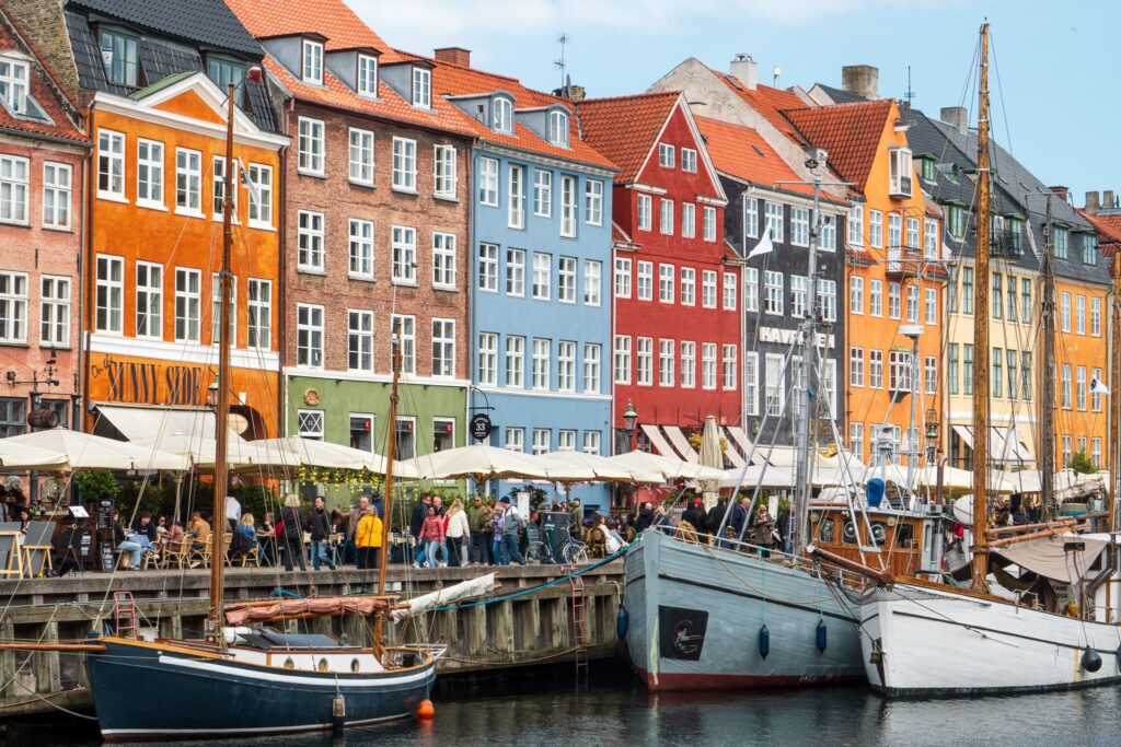 Boats stand still in the Nyhavn harbor in Copenhagen. This is an iconic spot to visit during a solo trip to Copenhagen.