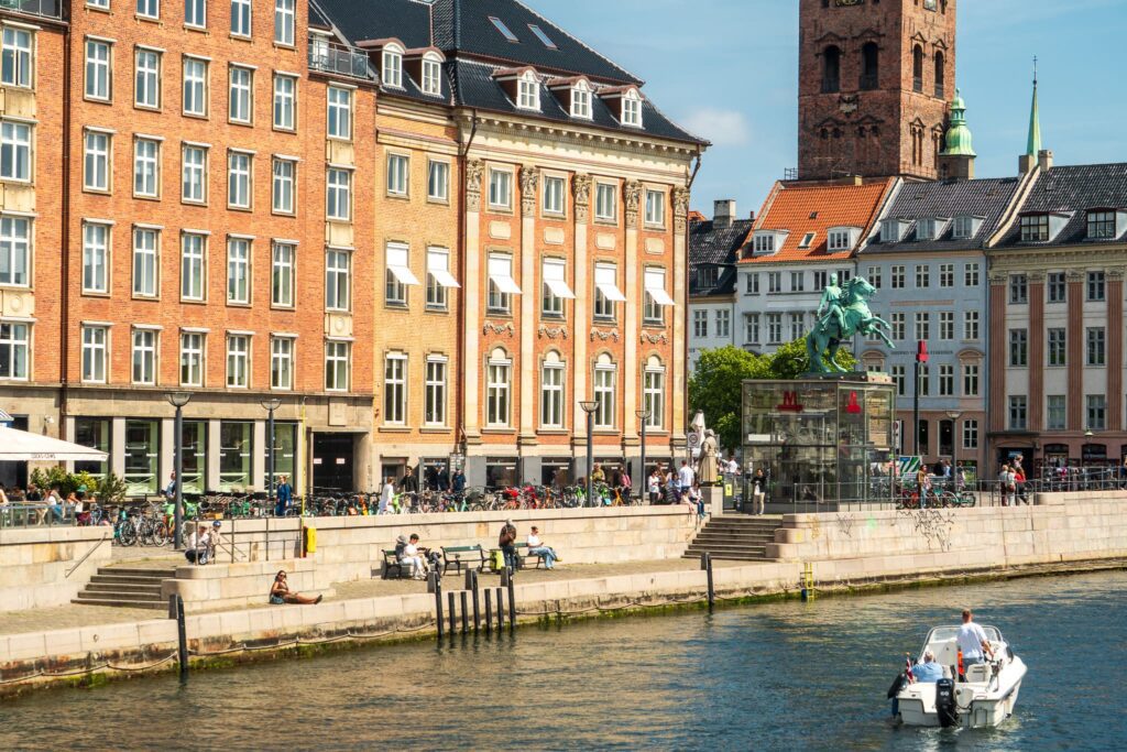 A boat passes through a canal in Copenhagen, Denmark.